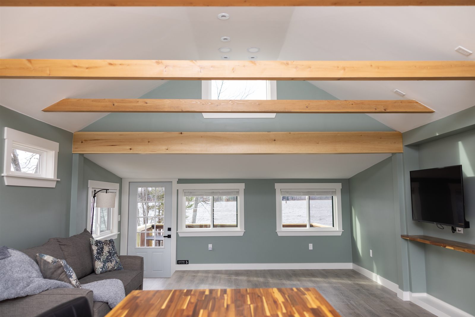 Living room with lake-facing windows and wood beams